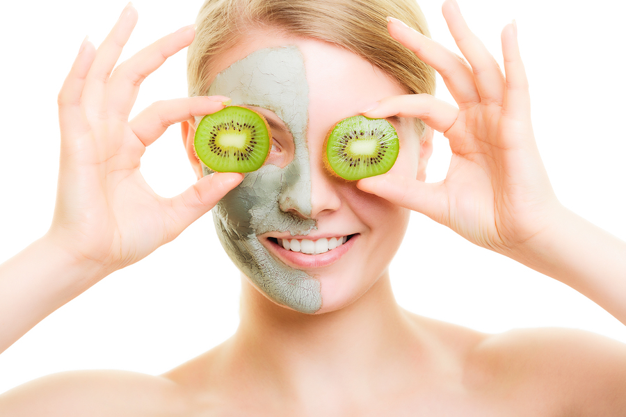 Woman In Clay Mask With Kiwi On Face.