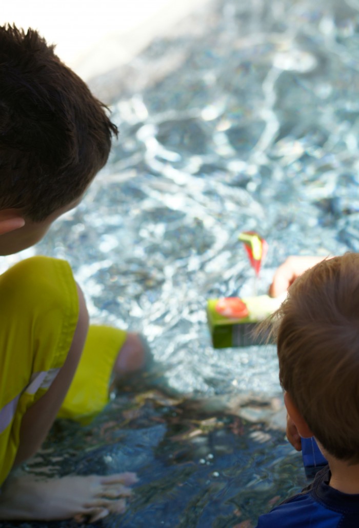 Looking for fun and free at home outdoor summer activities for kids? These DIY Juice Box Boats are a great way to take up an afternoon- build them by upcycling things from around the house and then set sail!