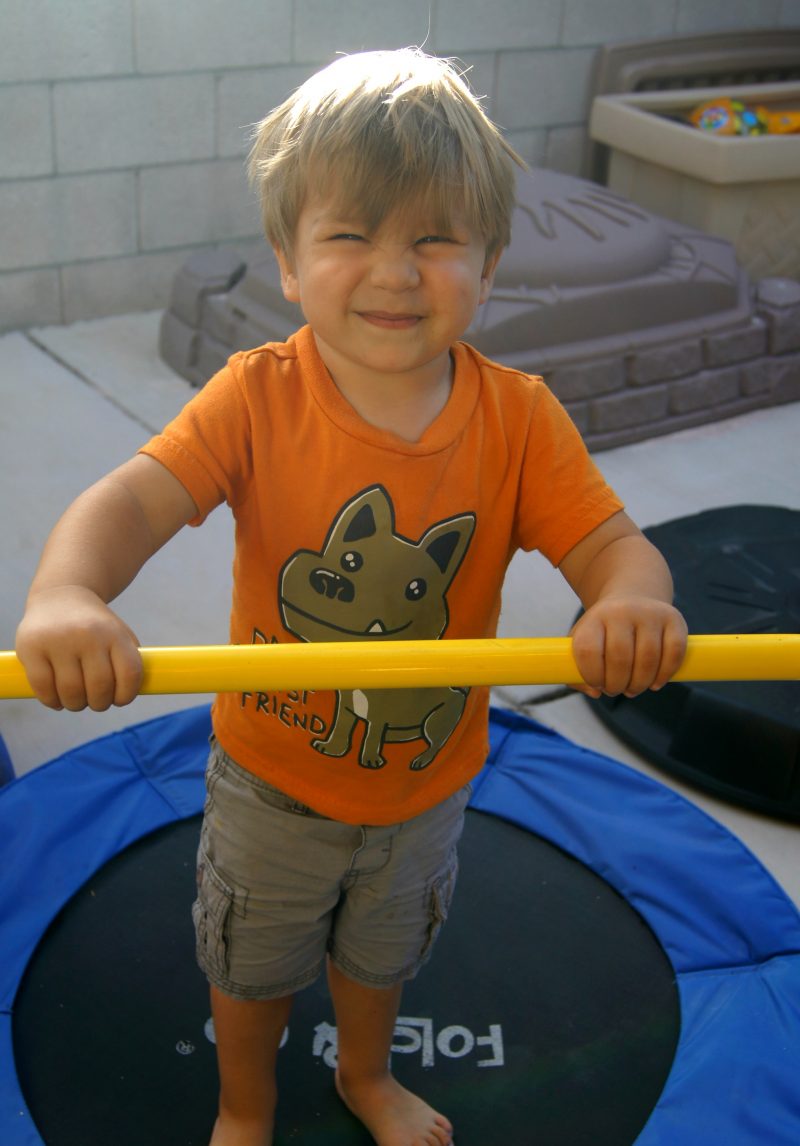 Kid playing on trampoline in backyard