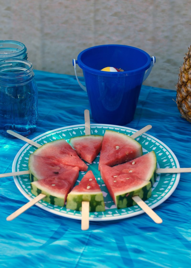 Need ideas for your Backyard Beach Theme Party? Whether you’re having a Hawaiian Luau birthday party or just celebrating summer with the kids, we’ve got you covered! From the mason jar decorations to the DIY beach ball Frisbee game to the beach cupcakes, we’re sharing all kinds of food, games, and décor ideas to make your party fun in the sun!