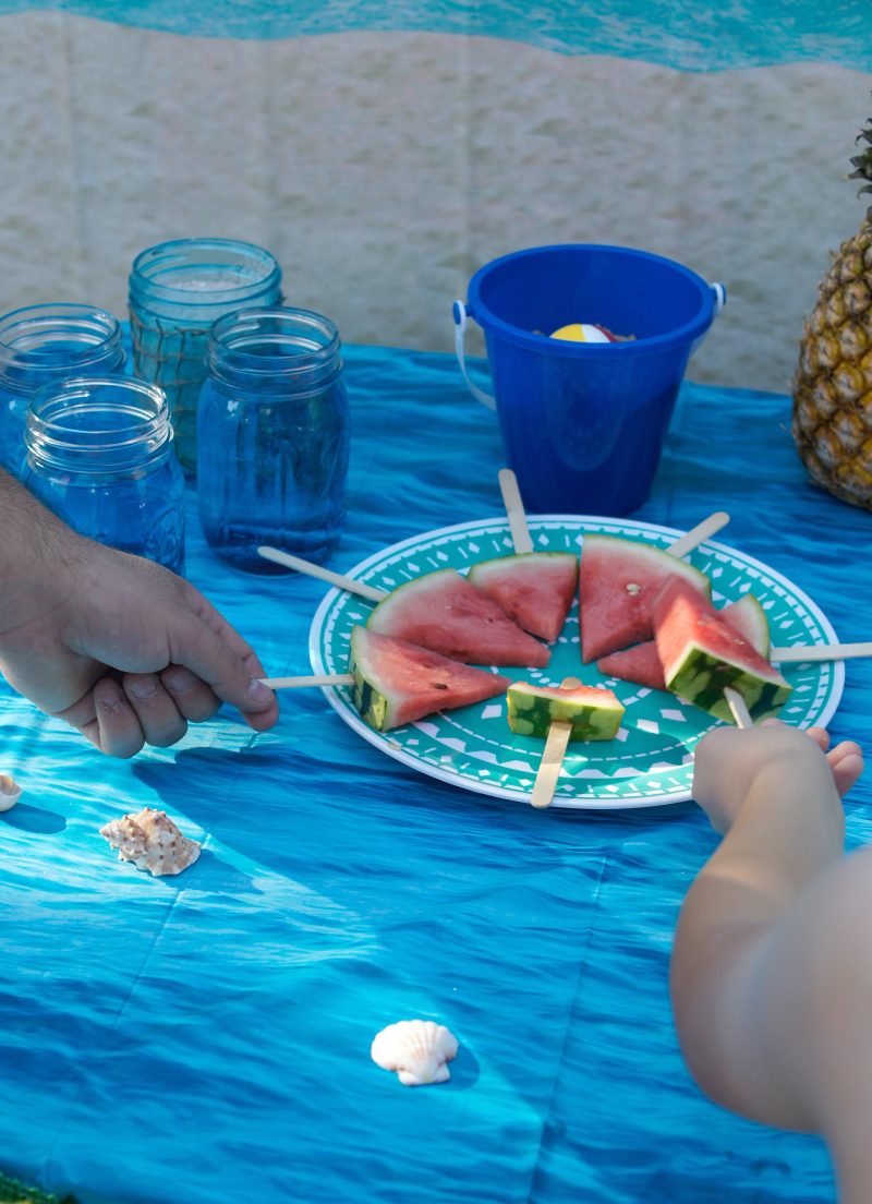 Need ideas for your Backyard Beach Theme Party? Whether you’re having a Hawaiian Luau birthday party or just celebrating summer with the kids, we’ve got you covered! From the mason jar decorations to the DIY beach ball Frisbee game to the beach cupcakes, we’re sharing all kinds of food, games, and décor ideas to make your party fun in the sun!