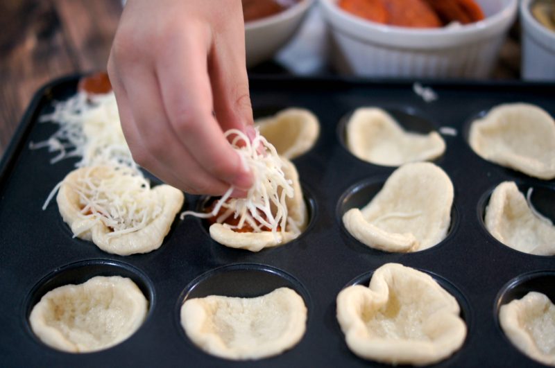 If you’re looking for a delicious, easy to customize appetizer for your next football party or tailgate, try these easy Mini Pizza Bites! You can add whatever toppings you like {think mushrooms, pepperoni, sausage, pineapple, bacon, olives- whatever!} and when you bake them in the Wilton Perfect Results Mega Muffin tin you get 48 of them per batch! That’s one way to win on game day! 