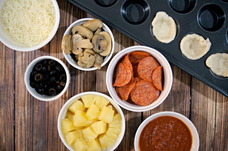 If you’re looking for a delicious, easy to customize appetizer for your next football party or tailgate, try these easy Mini Pizza Bites! You can add whatever toppings you like {think mushrooms, pepperoni, sausage, pineapple, bacon, olives- whatever!} and when you bake them in the Wilton Perfect Results Mega Muffin tin you get 48 of them per batch! That’s one way to win on game day! 