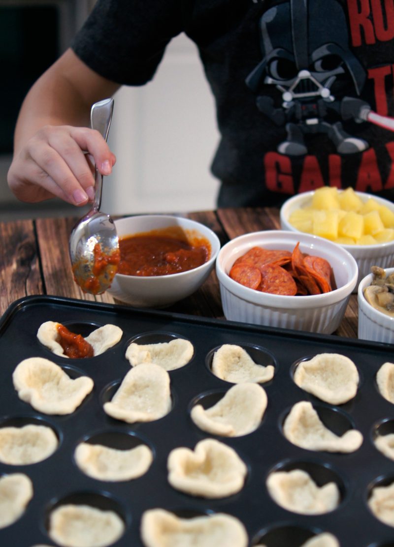 If you’re looking for a delicious, easy to customize appetizer for your next football party or tailgate, try these easy Mini Pizza Bites! You can add whatever toppings you like {think mushrooms, pepperoni, sausage, pineapple, bacon, olives- whatever!} and when you bake them in the Wilton Perfect Results Mega Muffin tin you get 48 of them per batch! That’s one way to win on game day! 