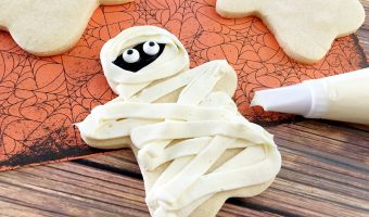 These easy DIY Homemade Halloween cookies taste like sugar cookies with a hint of pumpkin- and they are decorated like mummies! While they look super cute, they are easy to make and they’re one of my favorite Halloween recipes for kids.