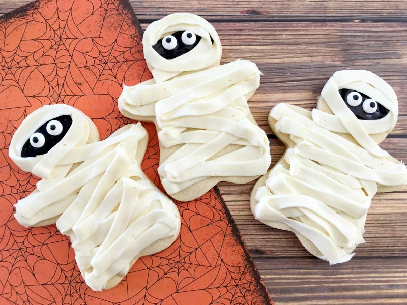 These easy DIY Homemade Halloween cookies taste like sugar cookies with a hint of pumpkin- and they are decorated like mummies! While they look super cute, they are easy to make and they’re one of my favorite Halloween recipes for kids.