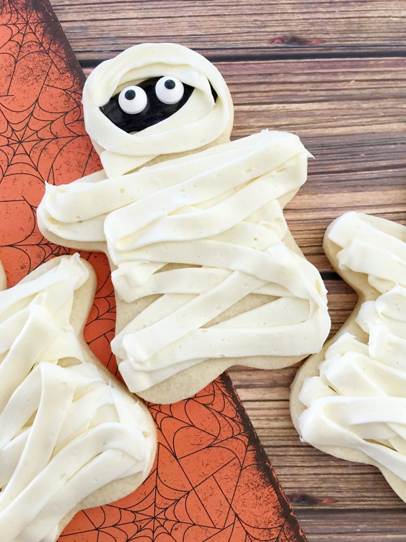 These easy DIY Homemade Halloween cookies taste like sugar cookies with a hint of pumpkin- and they are decorated like mummies! While they look super cute, they are easy to make and they’re one of my favorite Halloween recipes for kids.