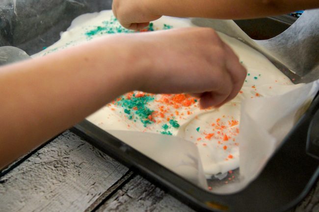 This easy 4th of July inspired red, white and blue candy bark recipe is so much fun to make- and even more fun to eat! This candy pops when you eat it for a fireworks show right in your mouth! You could use this idea for other holidays too, like birthday parties, Christmas, or even Halloween. Just pick any color from the rainbow for your chocolate and your candy!