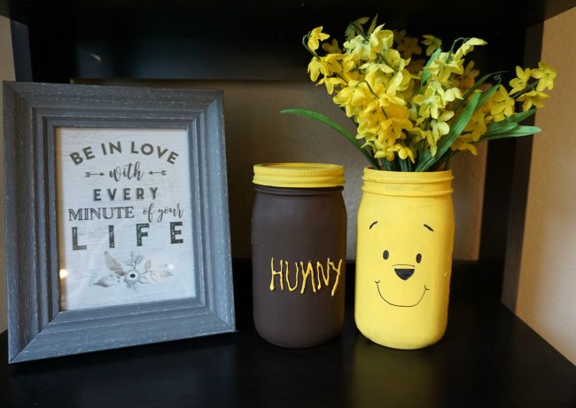 Winnie the Pooh is full of so many adorable characters and memorable quotes- and Disney’s Christopher Robin is sure to be the same! I can’t wait to visit the Hundred Acre Wood again and to celebrate, I made these adorable painted DIY mason jar vases featuring Winnie the Pooh and his Hunny Pot. You could use these vases for flowers, as a centerpiece for a baby shower, or as storage in the nursery for baby keepsakes! The vases can even be repurposed for older kids as bathroom storage!