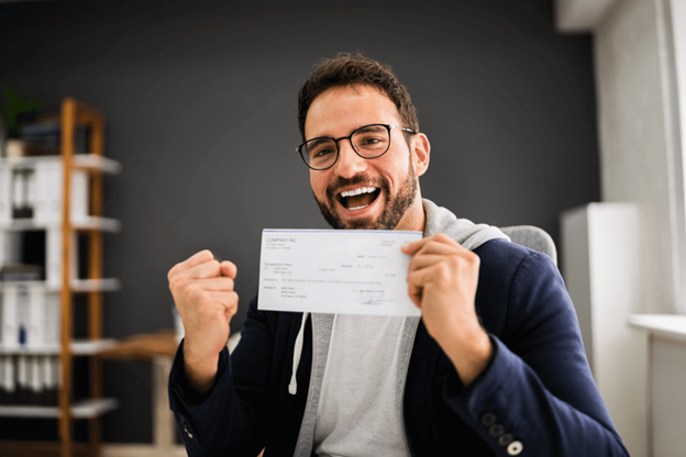 man holding paycheck looking happy