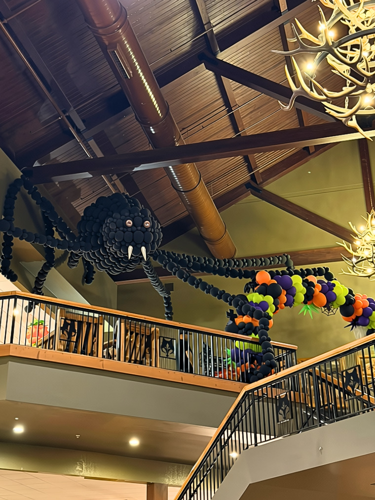 Giant black balloon spider and Halloween balloon garland hanging in the Great Wolf Lodge Garden Grove Anaheim lobby for Howl-O-Ween